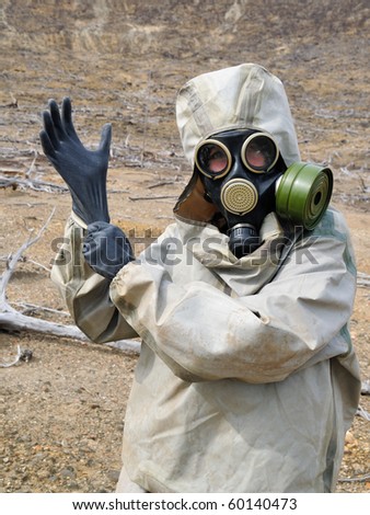 The person in chemical protection suites puts on gloves
