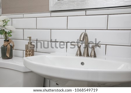 Bathroom sink shot close up with a modern design white subway tile backsplash