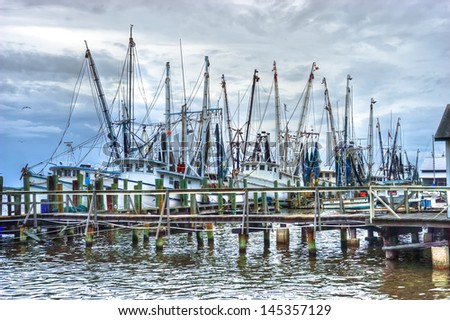 Atmospheric HDR image of a fishing fleet in the harbor in the early morning light.  All boat names removed.