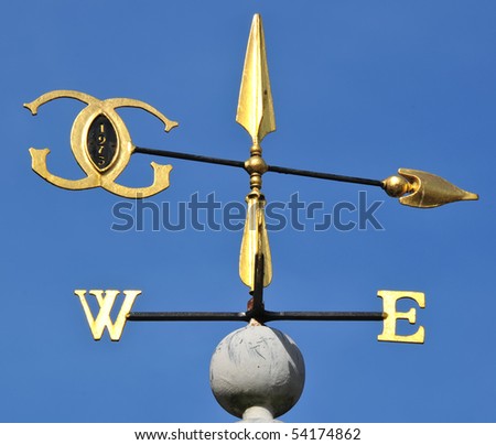 Golden wind vane against a clear blue sky