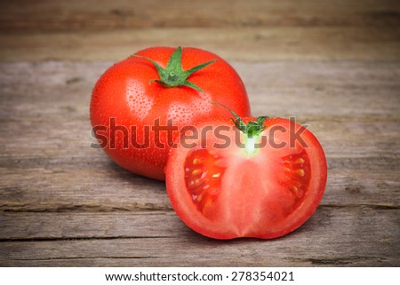 Ripe Organic Tomatoes with water drops on the old wooden table