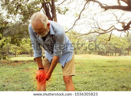 Aging man having pain in his knee on the park, Pain In The Elderly, Health care