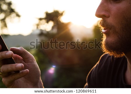 young man with beard and mobilephone