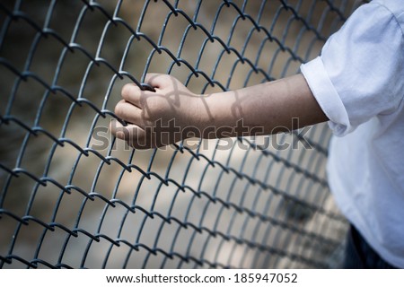 child hand in jail , hand clutching prison,no escape