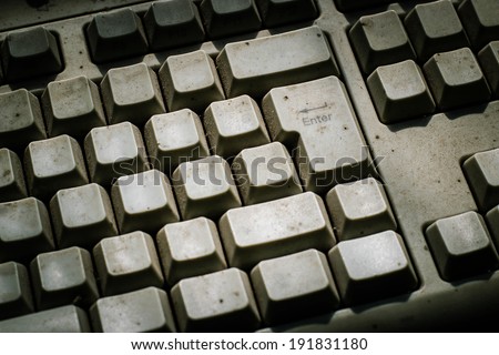 A close view of some keys on a dirty, yellowed keyboard. close up enter button