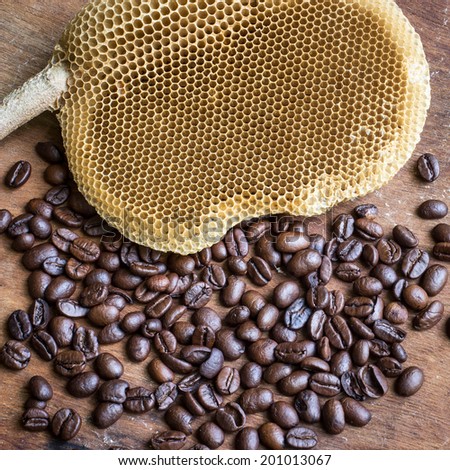 honeycomb with honey and coffee beans on wood background,abstract