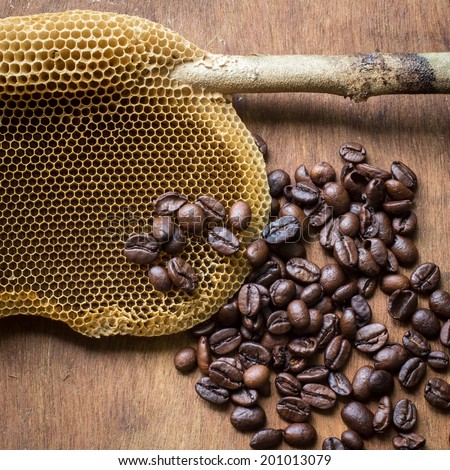honeycomb with honey and coffee beans on wood background,abstract