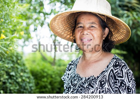 Asian senior woman at park, thailand woman smiling happily.