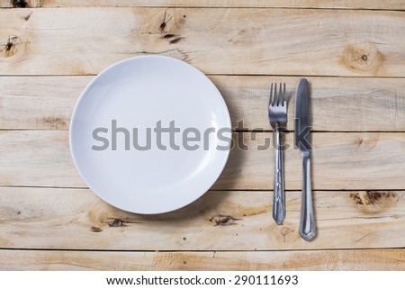 plate and silverware over white wooden background, View from above,on top