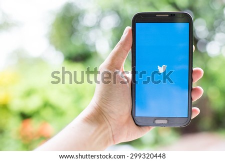 UDON THANI,THAILAND - July 24, 2015: man holding a brand samsung galaxy note 2 with Twitter logo on the screen. Twitter is a social media online service for microblogging and networking communication.
