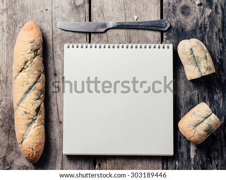 Moldy old bread and note book ,steak knife on wood background