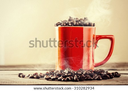 Grunge image of smoke on coffee beans with red cup, on wood table,hot coffee bean with red cup,vintage style