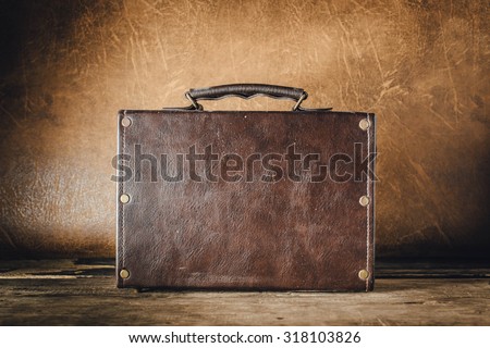 old vintage leather bag on old wooden floor with leather background