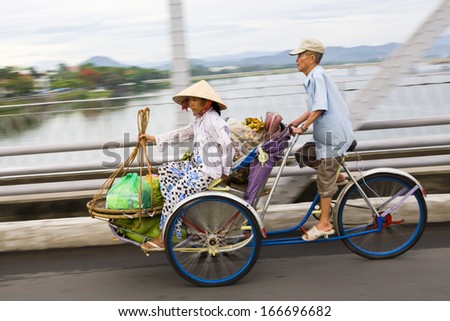 3 JUNE 2011 - HUE, VIETNAM - A woman transports her wares to market on a three-wheel cyclo bike, on 3 June 2011, in Hue, Vietnam