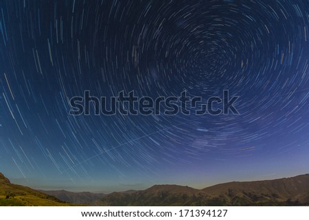 Star trails in the night sky over the Crown Range near Queenstown, New Zealand