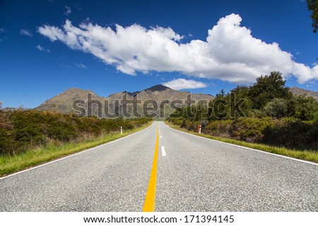 Road stretching to distance in countryside near Queenstown, New Zealand
