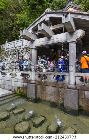 22 MAY 2014 - KYOTO, JAPAN - Children drink mountain spring water at Zen Buddhist temple Kiyomizu, Kyoto