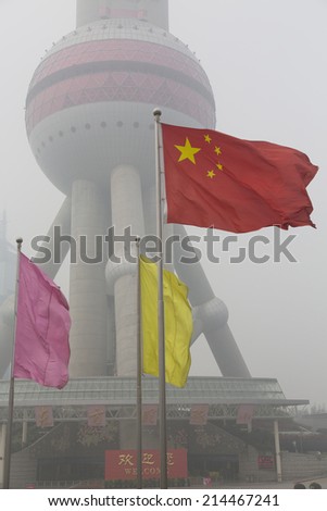 The Chinese national flag against the Oriental Pearl Tower on a heavily polluted day, Shanghai