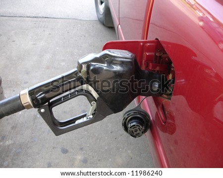 gas pump nozzle. stock photo : Gas pump nozzle filling up vehicle with gas.