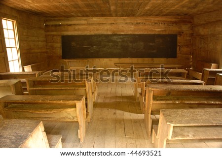 Vintage classroom desks inside a one room country school house. Looking from back to front.
