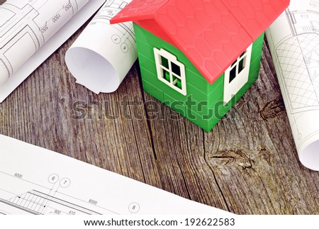 Image model home on design drawings in the background of wooden boards