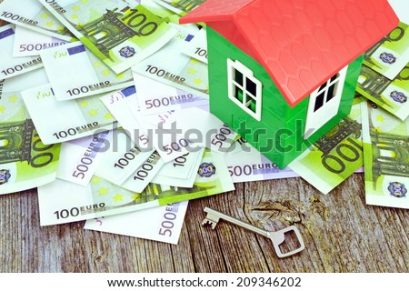 Model of house on money / Image of a model house standing on Euro banknotes