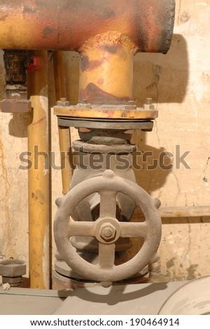 Old valve and heating pipes in old boiler room