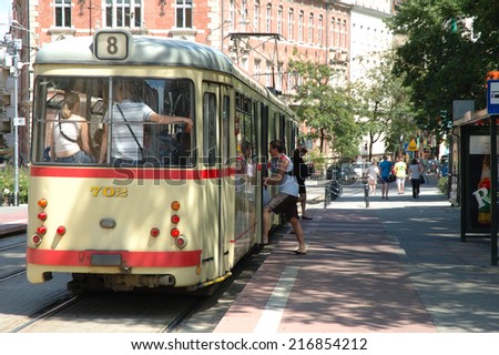 Poznan, Poland - July 13, 2014: Unidentified people getting on and off the tram on tram stop on Cyryla Ratajskiego square in Poznan, Poland