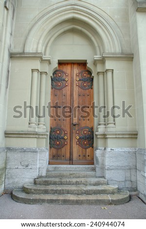 Old wooden brown church door and stone stairs