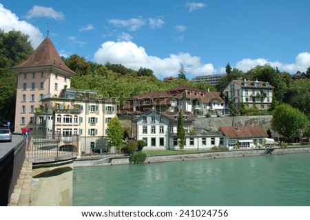 Bern, Switzerland - August 15, 2014: Buildings and trees at Aare river in Bern, Switzerland. Unidentified people visible.