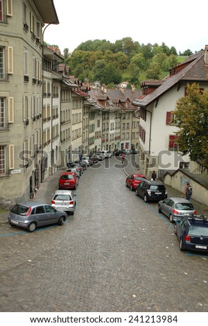 Bern, Switzerland - August 15, 2014: Buildings and unidentified people on cobbled street in Bern, Switzerland.