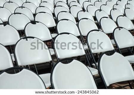 Empty white plastic chairs in open air cinema