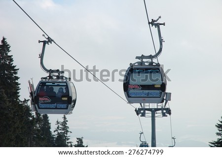 Janske Lazne, Czech Republic - February 17, 2015: Two cable cars on gondola lift on Cerna Hora mountain in Karkonosze mountains nearby Janske Lazne in Czech Republic. Unidentified people visible.