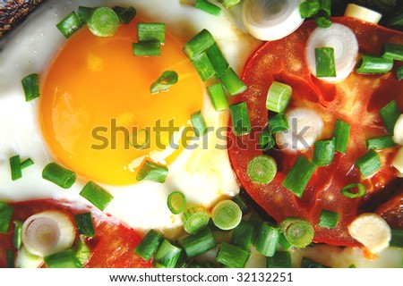 fried eggs with a tomato and spring onions