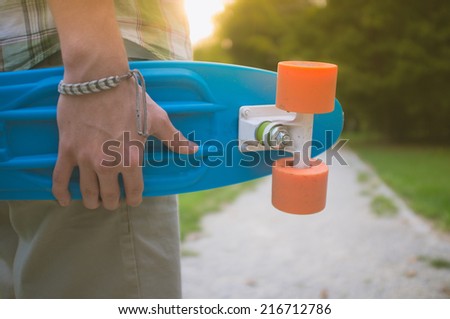 man in shirt holding skate board