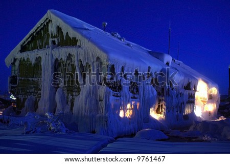 Beautiful idyllic cottage covered with snow. Idyllic night polar scene.