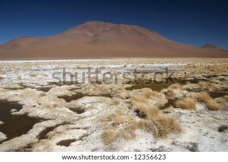 Mountain range with feature land full of small puddles of a drought lake. Altiplano. Bolivia.