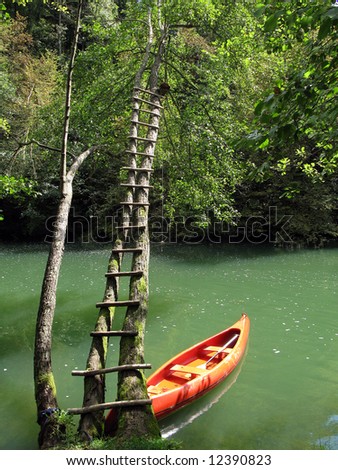 One canoe is waiting for canoing adventure on famous Slovenian river. River Krka. Dolenjska. Slovenia