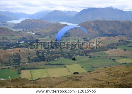 Paragliders in flight above the Queenstown countryside. South Island. New Zealand