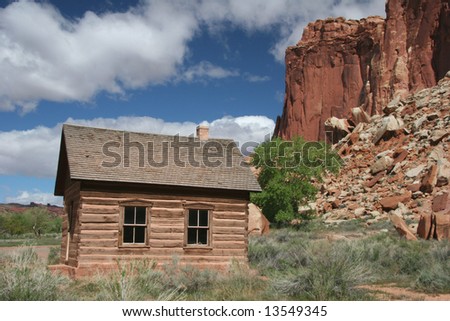 Historic one room log school house in Capitol Reef National Park. Geologic features in background. Utah. USA