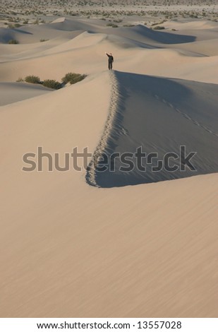 Footsteps with a person waving in sand dunes. Death Valley national park. California. USA