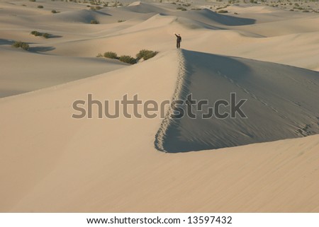 Footsteps with a person waving in sand dunes. Death Valley national park. California. USA