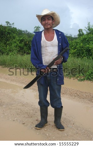 GUATEMALA -  JUNE 23: Indigenous man with a had holding a machete and posing in the middle of a country road. Great Trekking adventure June 23, 2005 in Guatemala.