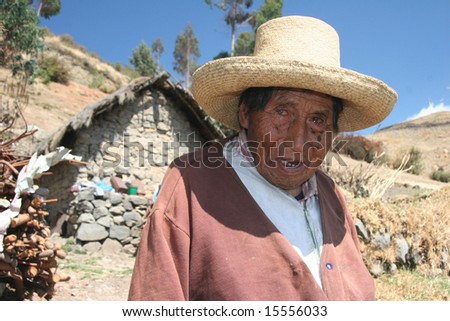 PERU - SEPTEMBER 19: Old indigenous man in traditional clothes posing in front of a poor stone house. Great trekking adventure September 19, 2005 in Peru.