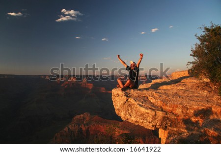 Trekker gesturing with raised arms. Grand Canyon at sunset. Grand Canyon national park. Arizona. USA