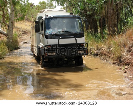 Australian dirt road with a truck driving through a deep puddle of mud. Bungle Bungle national park, Western Australia. Australia