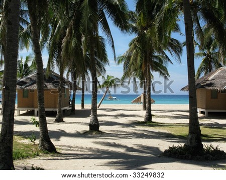 Traditional bungalows on idyllic island with sandy beaches, palm trees and turquoise clean ocean water. Budyong, Santa Fe, Bantayan island, Philippines