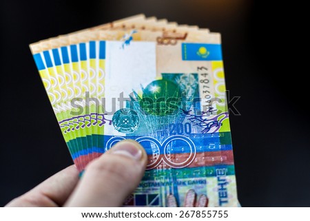 Tenge in hand, kazakh money. Kazakh paper money banknote 200 tenge, in your hand, close-up. Gesture shows reception or return of money.