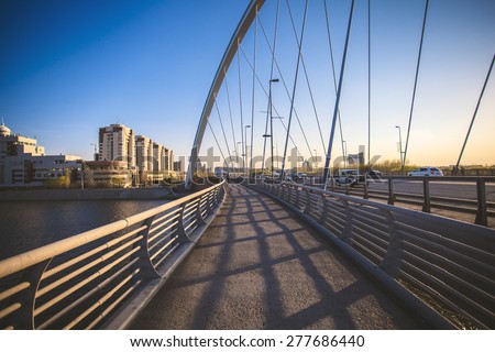 Astana, Kazakhstan - May 3, 2015: The photo was taken in Astana, capital of Kazakhstan. In the photo a bridge. Placed building and the structure of the city, and a river. Drive cars. People walk.