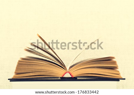 The opened book with the turned yellow pages on a light background from weaving